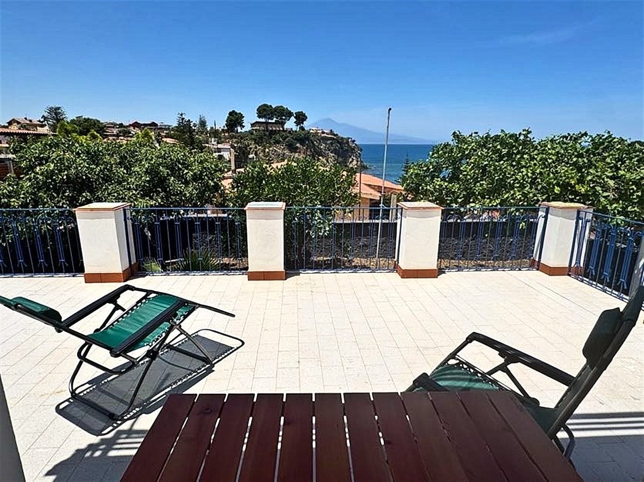 Terrace with loungers and a wooden table, sea view